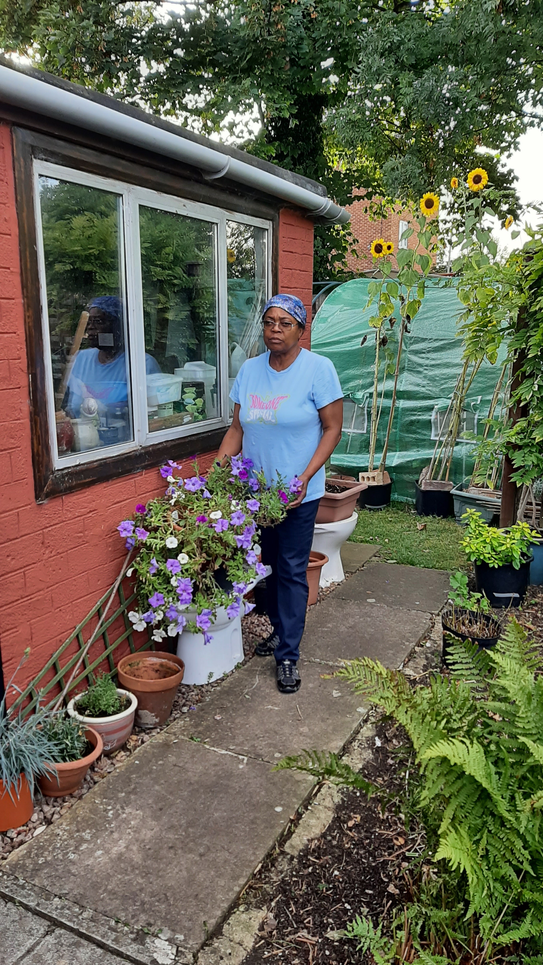 Image of Carol in her blooming garden in the summer from Carol’s personal photograph collection