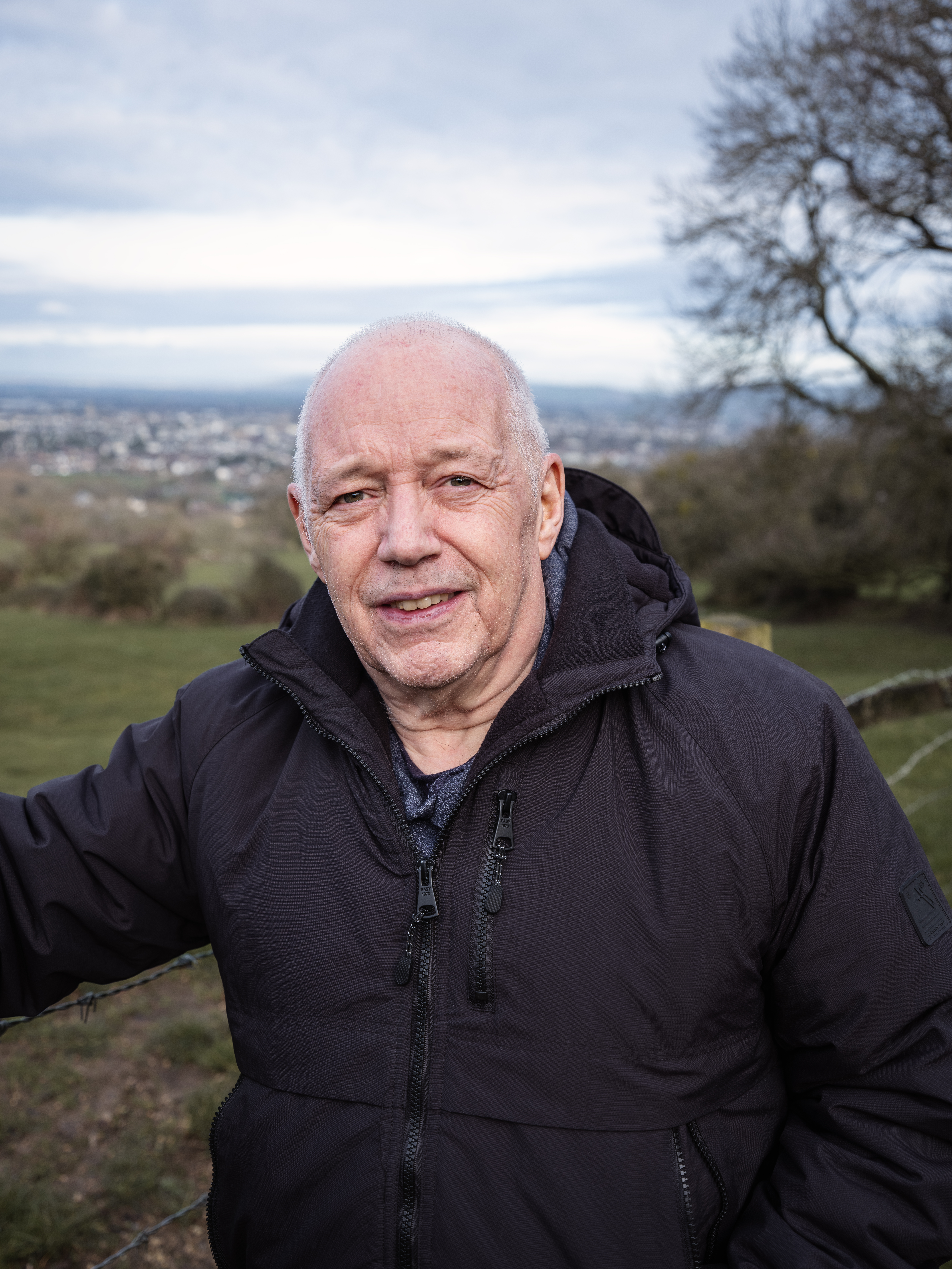 Alan he/him is a white man in his early 60’s he is pictured at his favourite location Leckhampton Hill in Cheltenham on a cloudy day. 