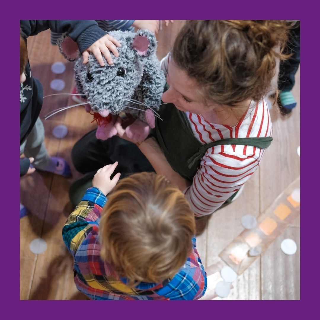 image of adult and child playing with a rat puppet