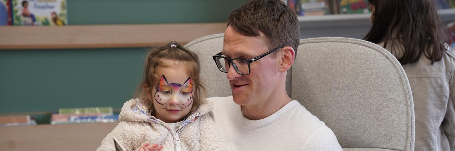 Father reading to daughter 