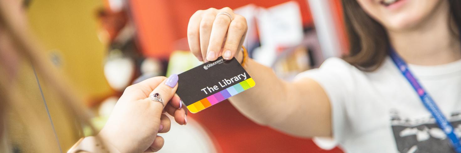 Library card being handed to library staff