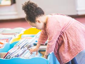 Little girl browsing through books