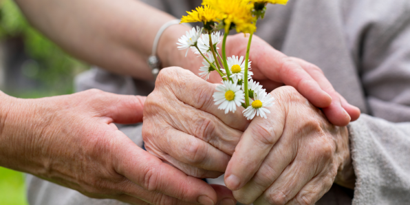 Older hands holding flowers