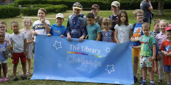 Children standing with The Library Challenge banner