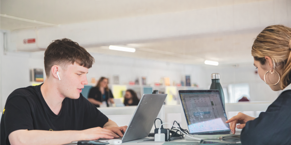 Young people using the library to work from laptop