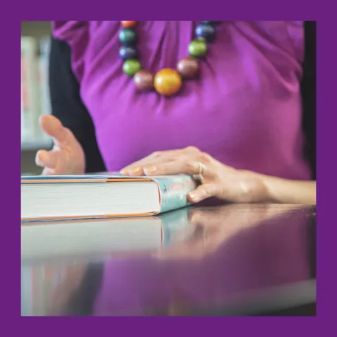 Woman sat at a table with a book in front of her