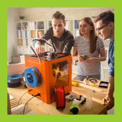 A photo of three adults working with a 3D printer