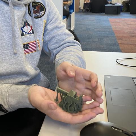 Young person holding their 3D printed model that they designed